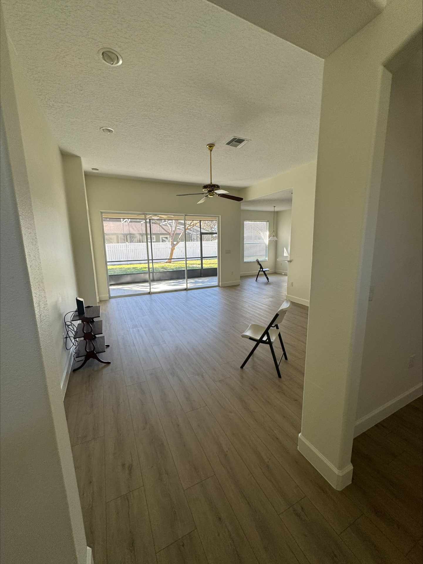 Open great room with new plank flooring and sliding glass doors to a screened lanai