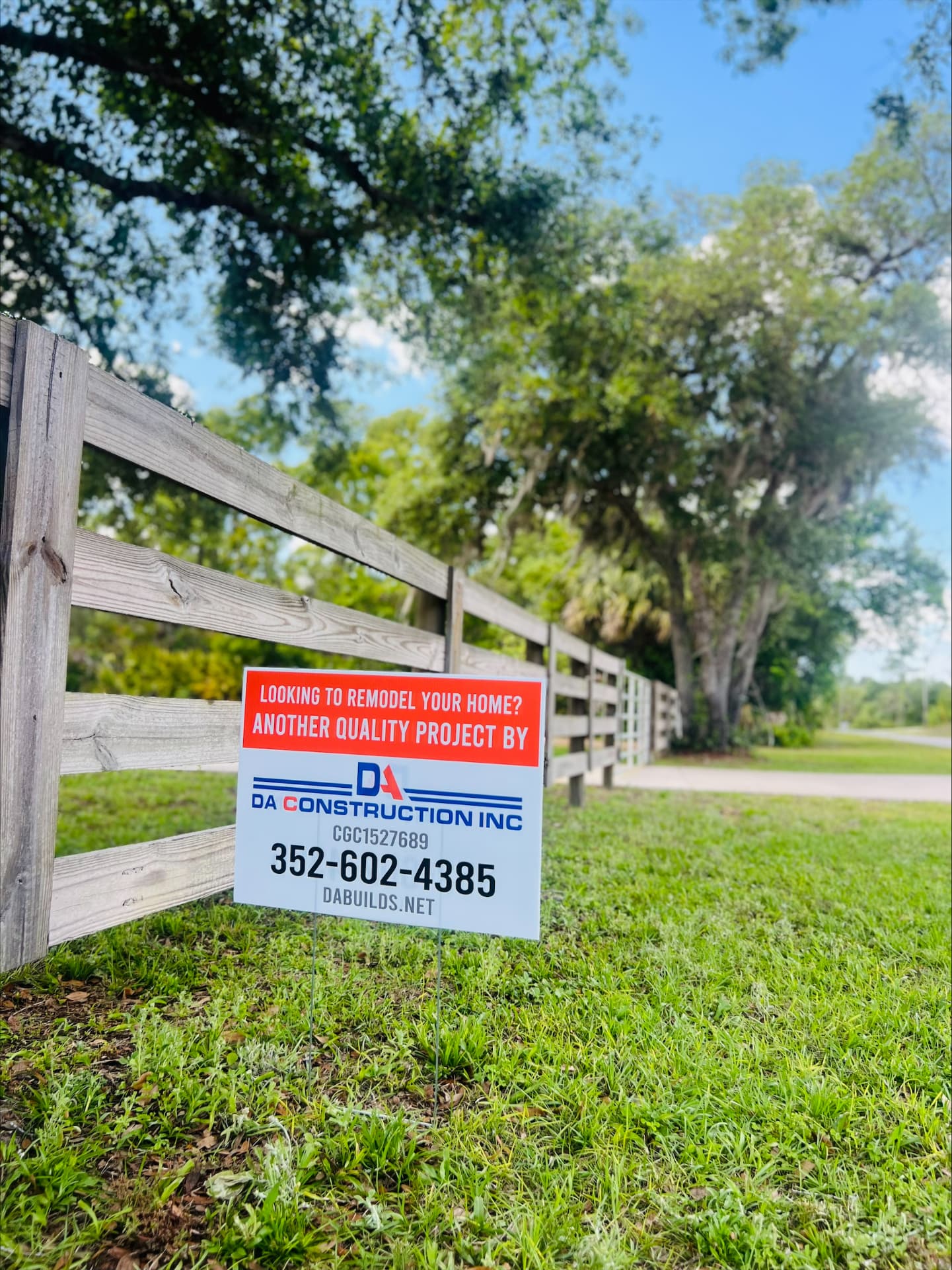 DA Construction jobsite yard sign along a wood fence line in Central Florida