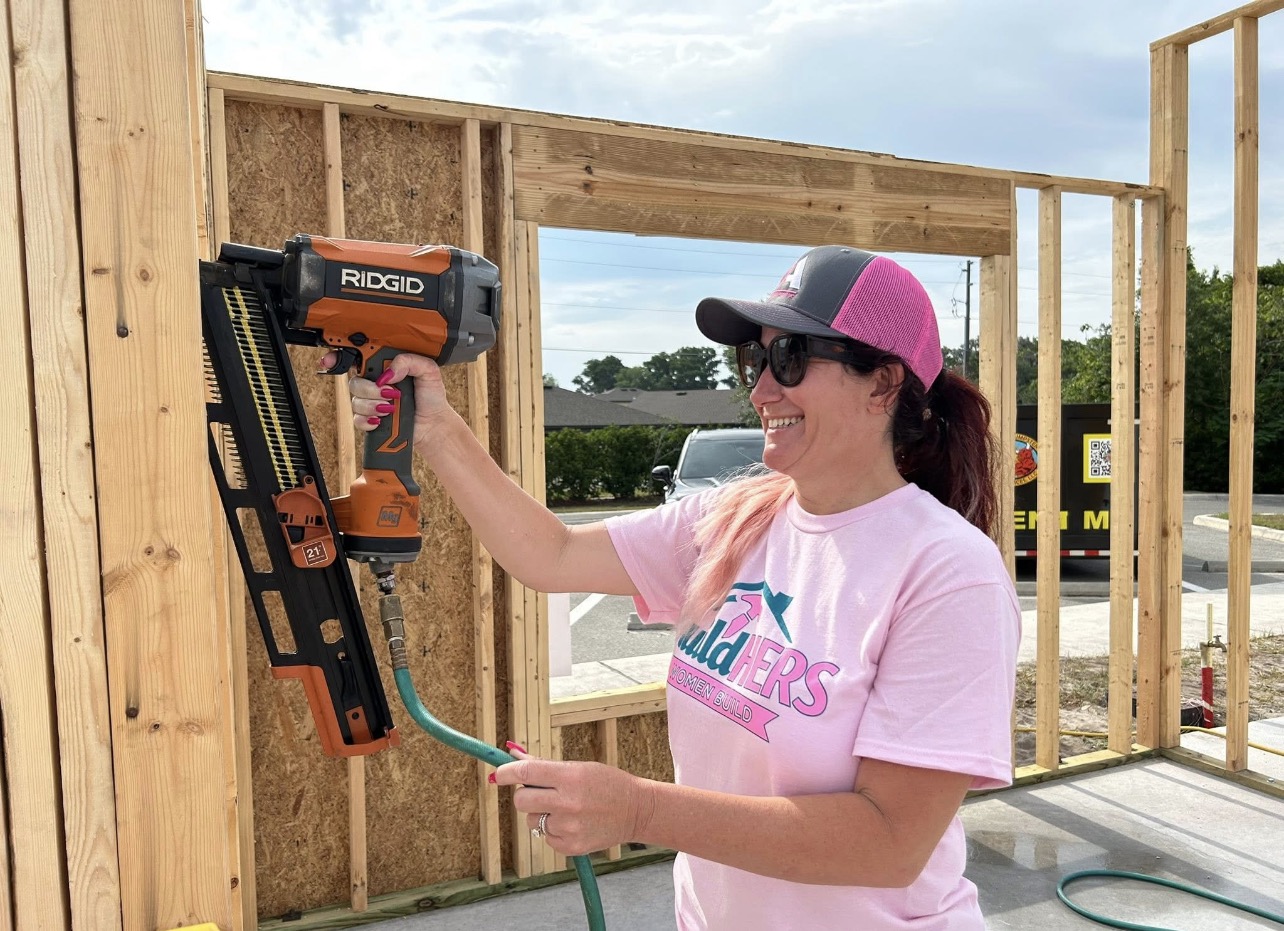 Volunteer using a framing nailer on a wall during the Habitat for Humanity Women Build