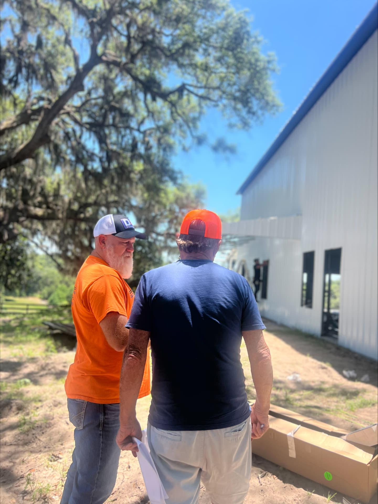 DA Construction superintendent walking the site with a client alongside a new metal building