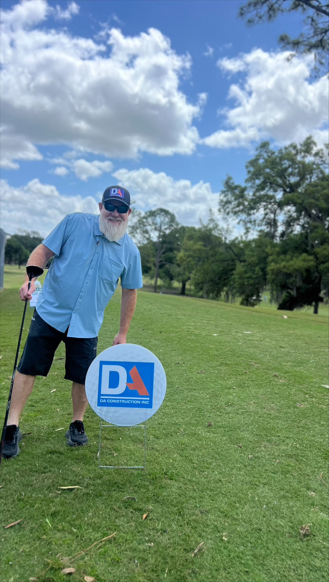DA Construction hole sponsor sign shaped like a golf ball at a charity golf tournament