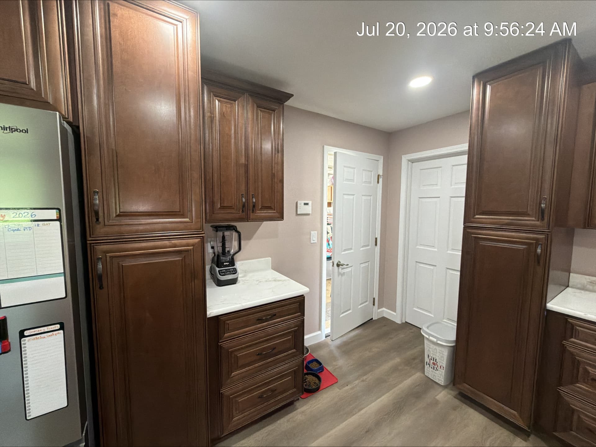 Tall walnut-stained cabinets with quartz counter and drawer bank in a remodeled kitchen
