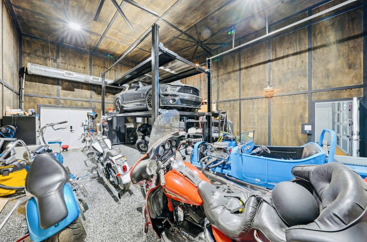 Finished metal-building garage and workshop with a vehicle lift, motorcycles and epoxy-style floors