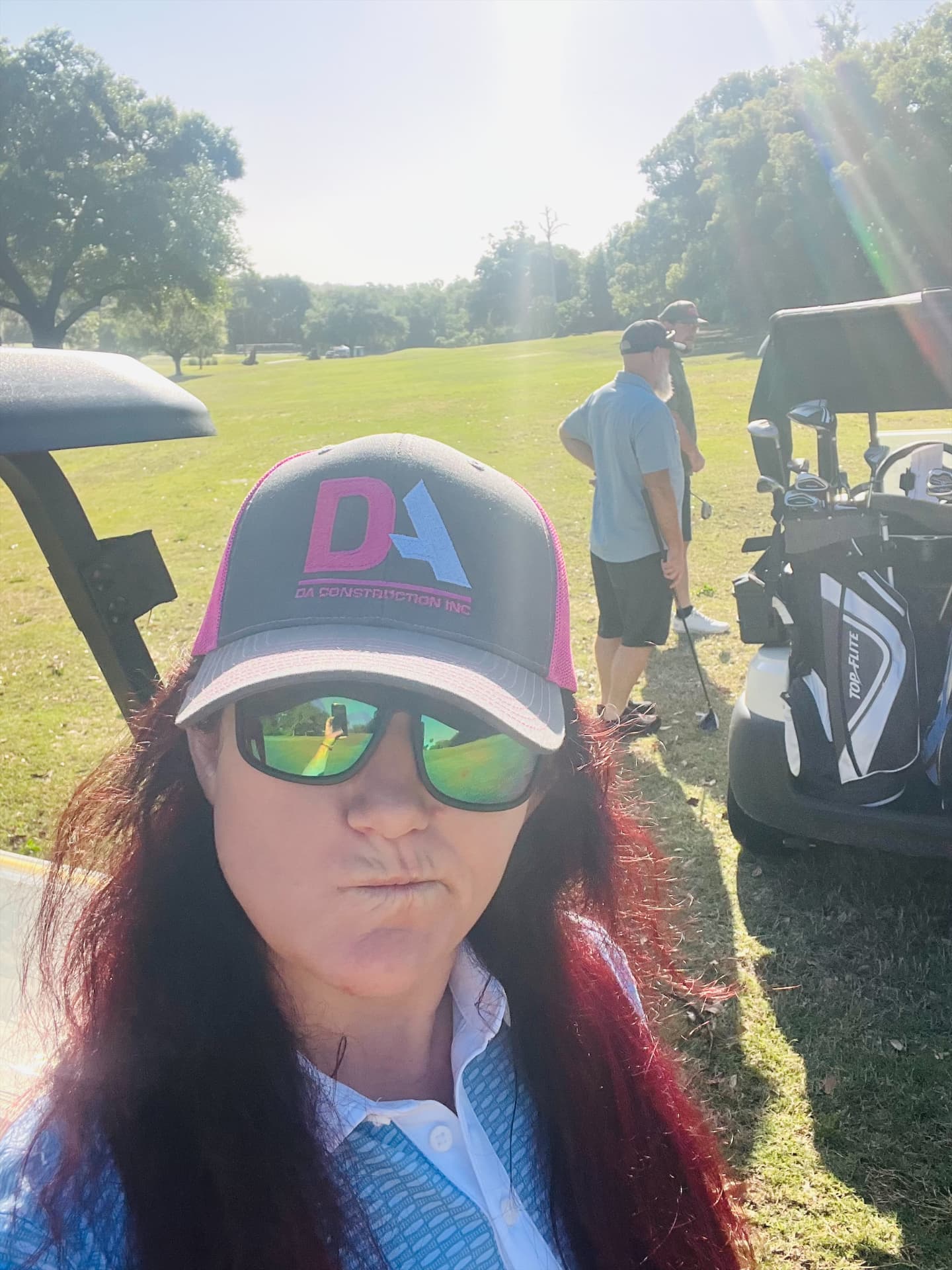 DA Construction team member in a branded DA cap at a charity golf tournament