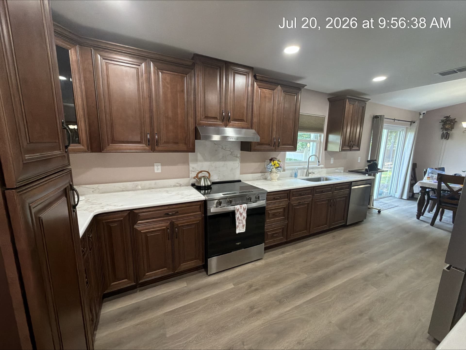 Range wall with stainless hood, quartz backsplash and walnut cabinetry