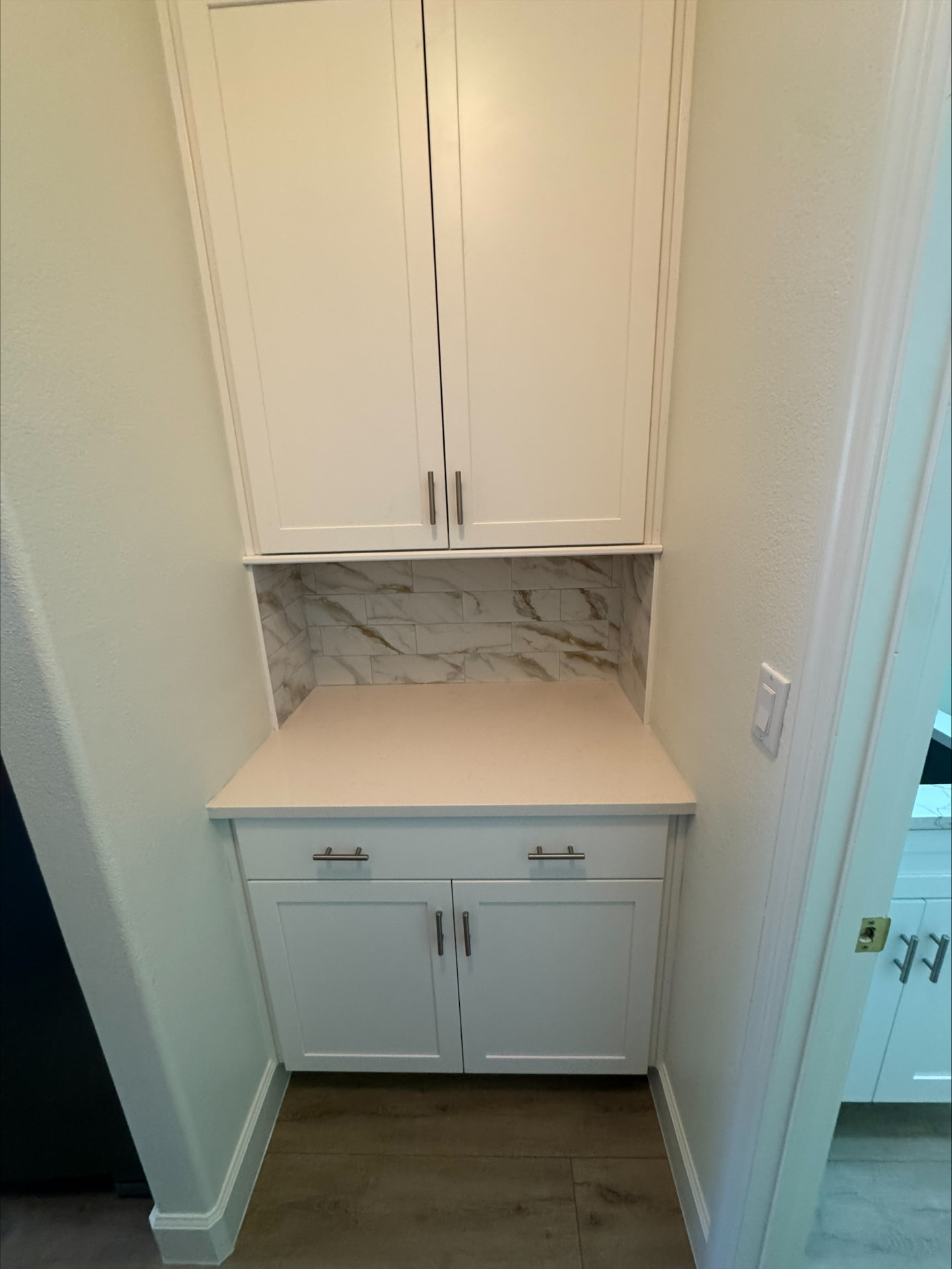Built-in coffee bar with white shaker cabinets, quartz counter and marble-look tile backsplash