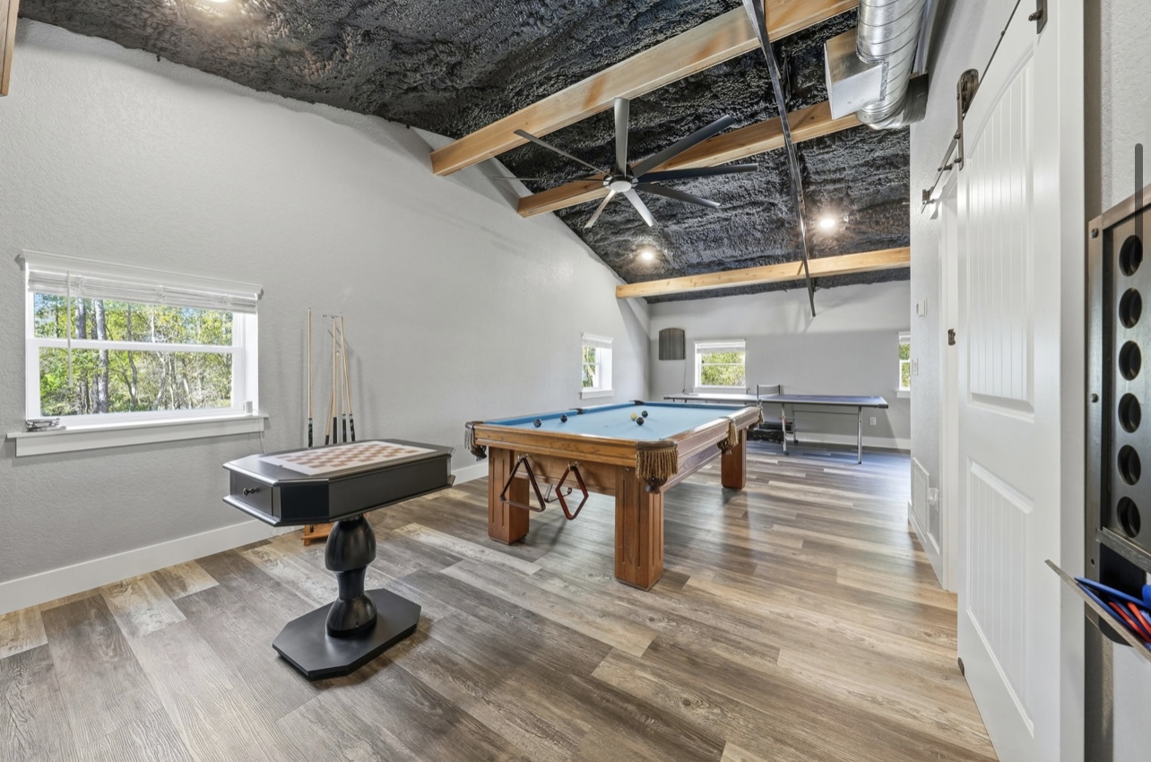 Second view of the game room with pool table and cue rack by the windows