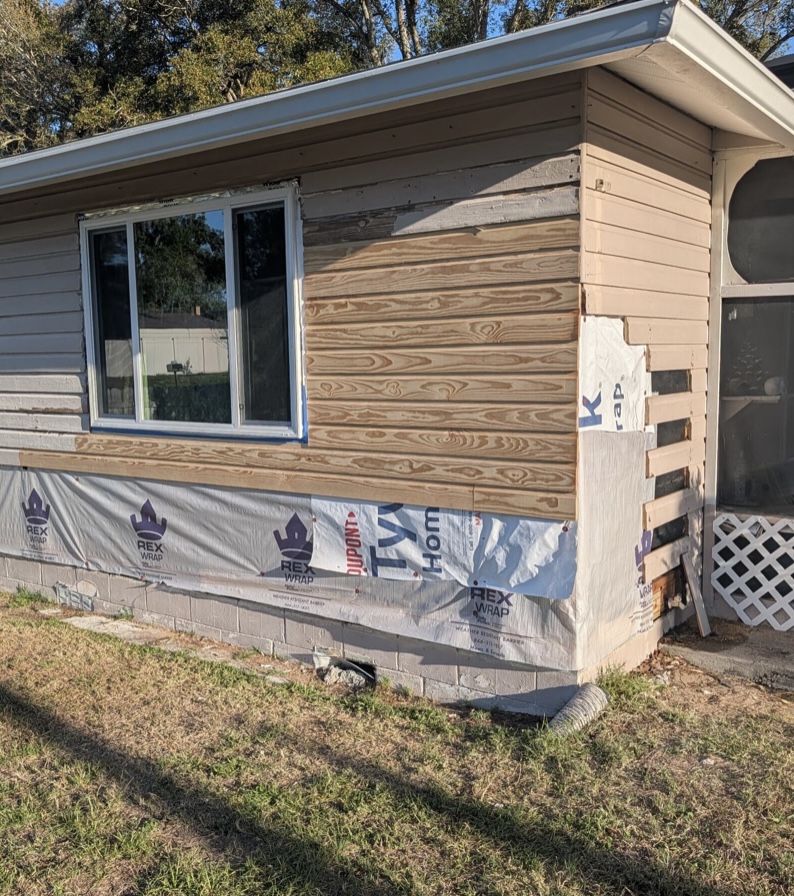 Home exterior with new house wrap and replacement lap siding partially installed