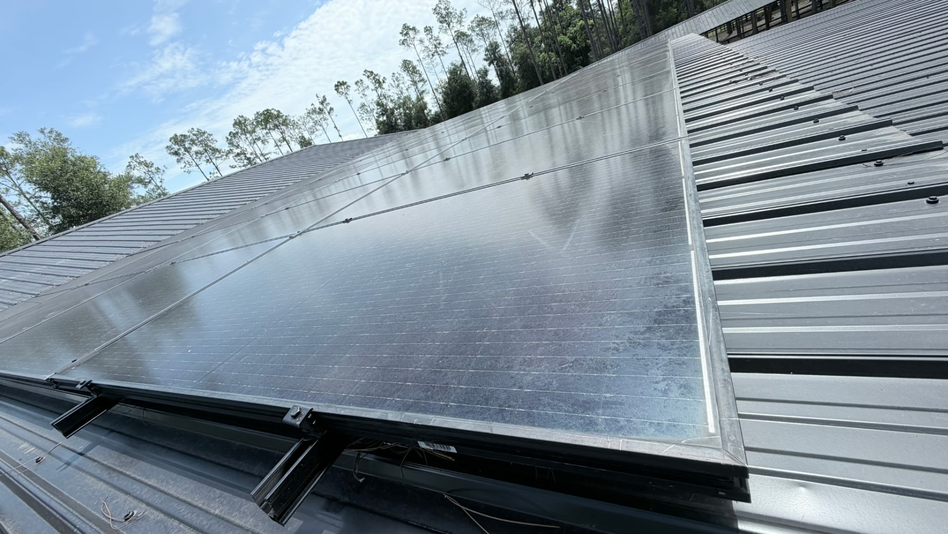 Close view of a solar panel and mounting rail on a metal roof