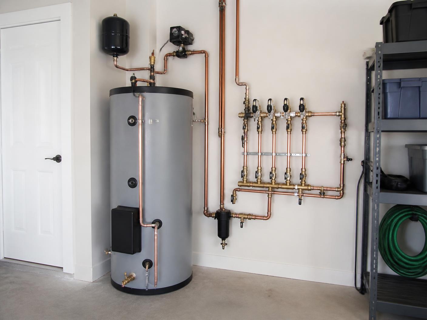 Solar hot water storage tank with copper plumbing manifold installed in a clean Florida garage